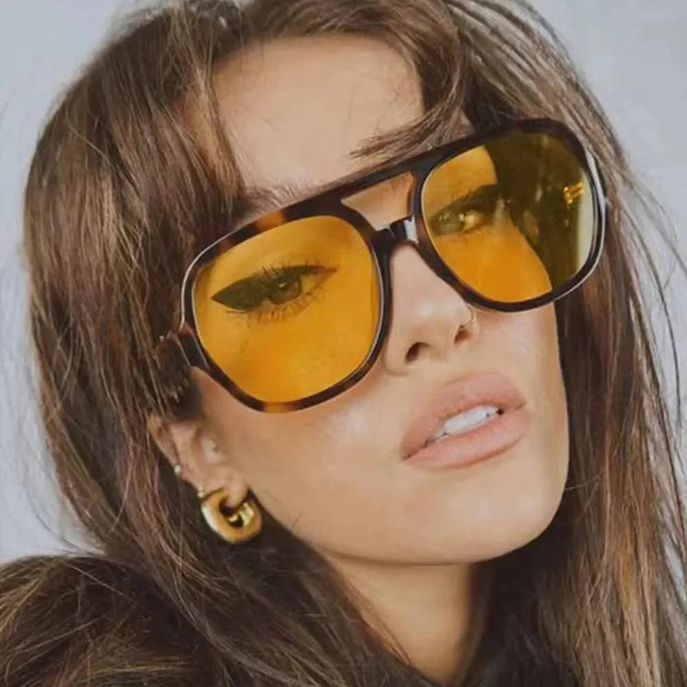 Close-up of 70s style yellow tinted aviator sunglasses worn